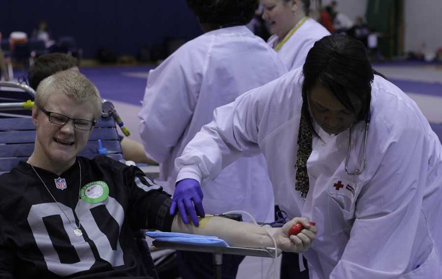 Senior Zachary Maas winces as a Red Cross nurse holds his IV in place during the StuCo blood drive on Jan. 30. 128 students, mostly juniors and seniors, signed up to donate blood.  