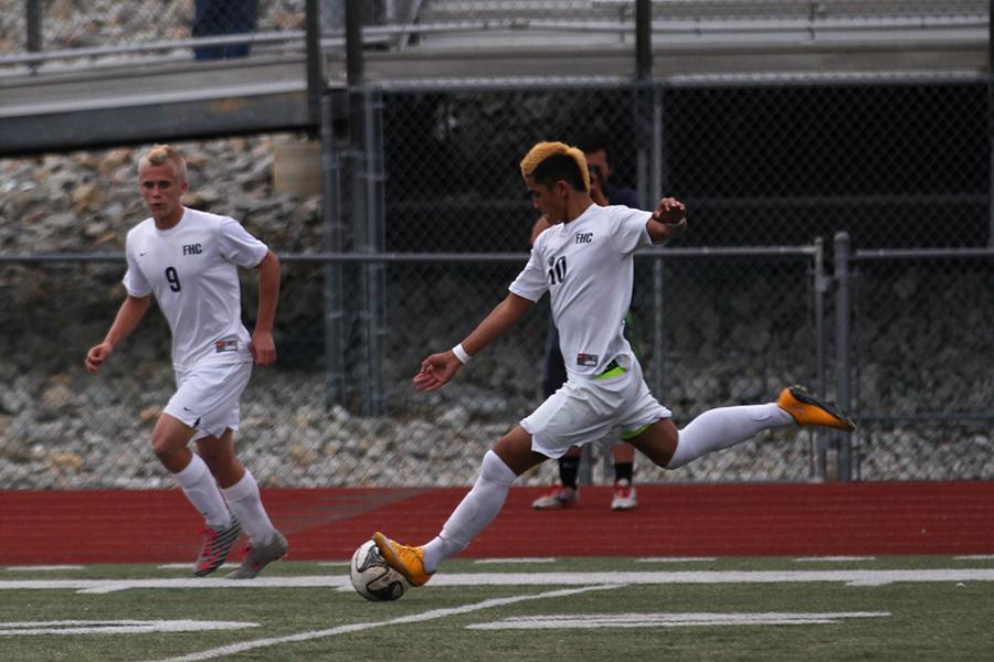 Senior Justin Stinson strikes the ball into the offensive half. Stinson has been on the varsity soccer team for four years.