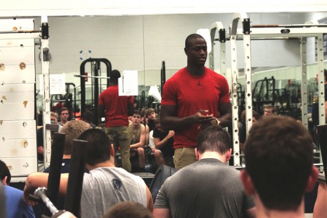 Alumnus Pierre Desir visits with the football players at their before school weight lifting session last Friday.