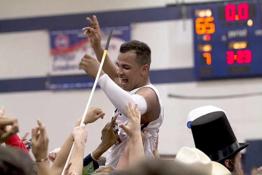 Senior Frank Davis is lifted by the fans after the varsity boys basketball team beat Howell 65-58. 