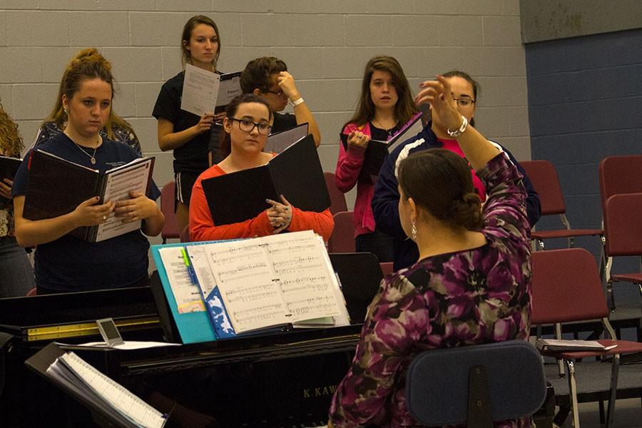 Choir director Elisabeth Baird gestures to the members of her third hour Treble Choir class. The choirs are making plans to make themselves  visible  this year, including singing during passing periods or pep assemblies. 