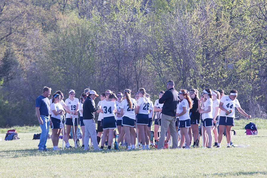 Lacrosse+team+meets+on+the+field.