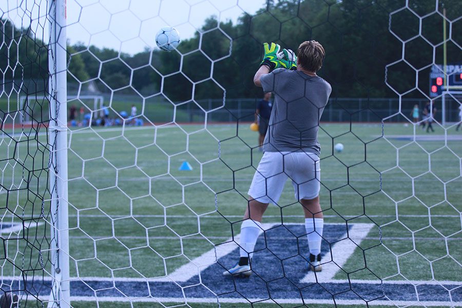 Goalie Nathan Smith warms up before a game. The soccer team are 8-9.