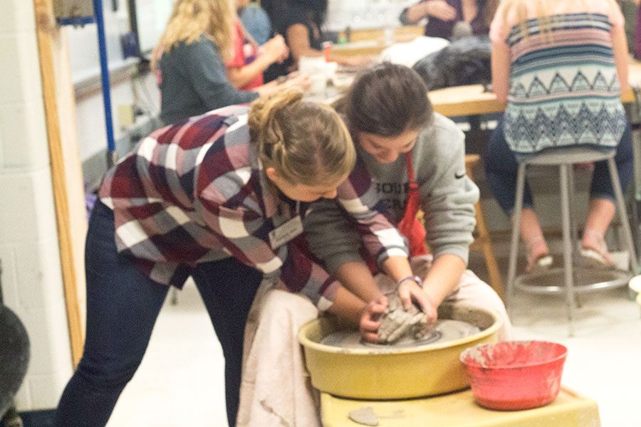 Sophomore Grace Painter is receiving help from Ms.Allen, on the pottery wheel. Grace was having trouble centering her ball of clay, which is getting the clay in the center and having it stay there. She is making a bowl. 