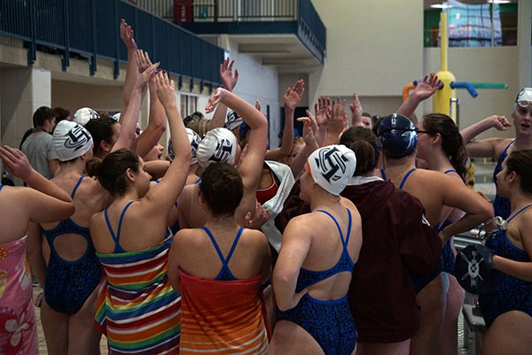 The girls swim team gets pumped up during the first day of the GAC swim and dive meet on Feb. 7. Eight members of the team qualified for the second day of the GAC meet. 