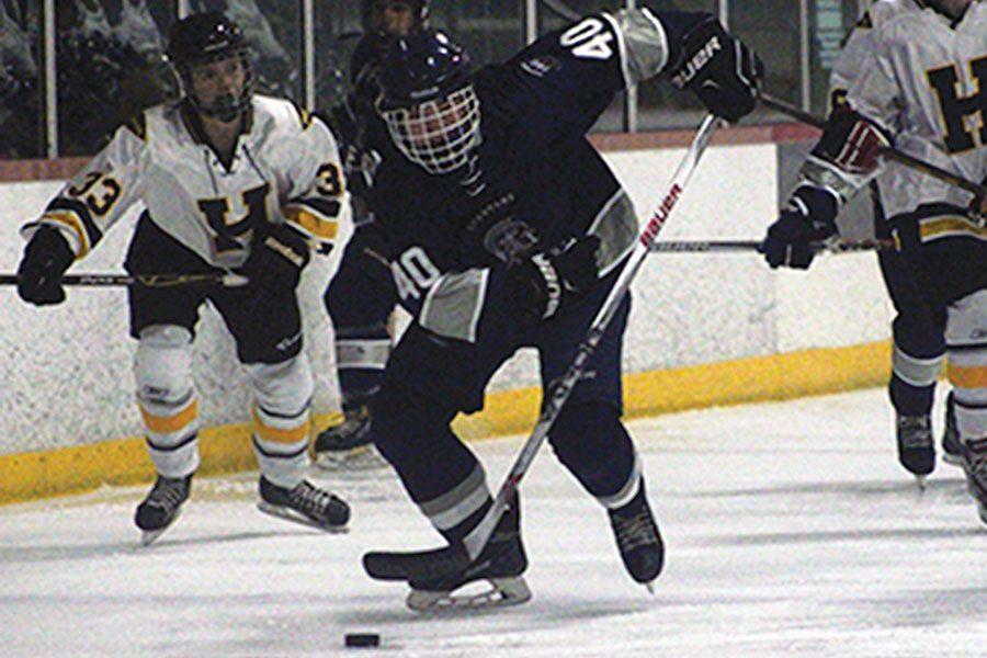 Junior, Corey Moats, breaks free of opponent, Holt High, and skates the puck down the ice. He scored two out of three goals this game, but unfortunately, the team lost in overtime. 