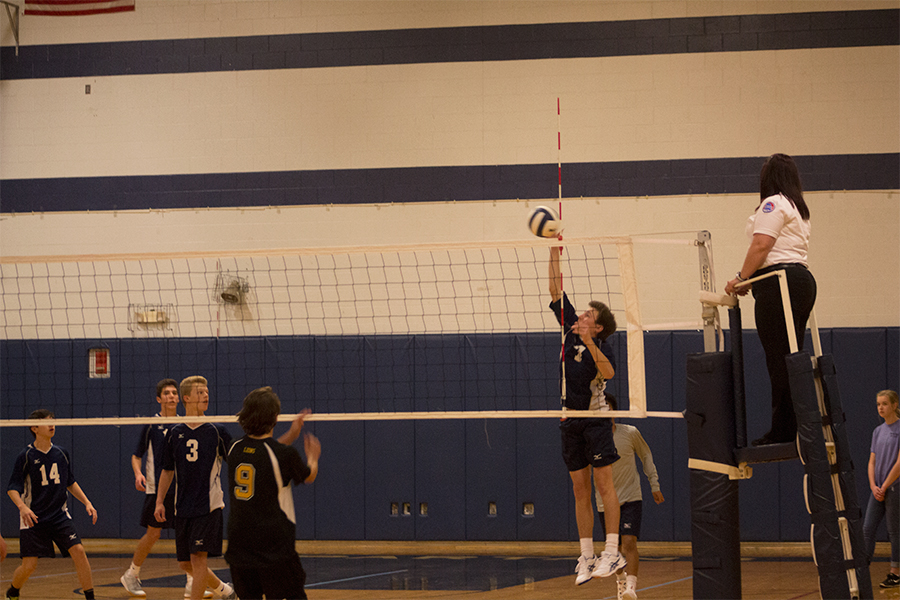 Dylan Stover tapping the ball over the net. The freshman team is undefeated with a record of 11-0.