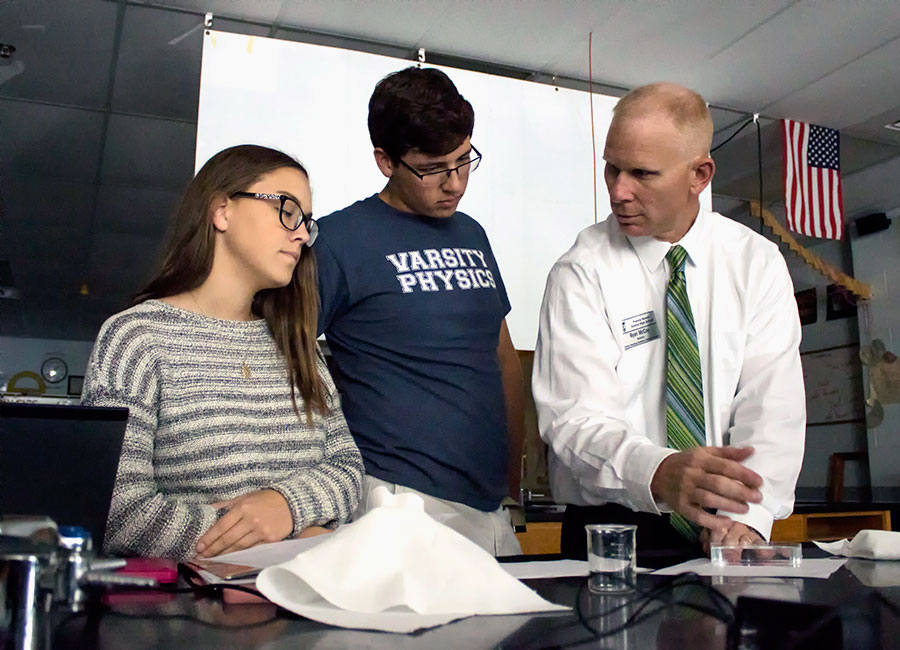 Mr. McCoy assists students in a lab. He teaches Physical Science, Physics, and AP Physics 1 and 2. 