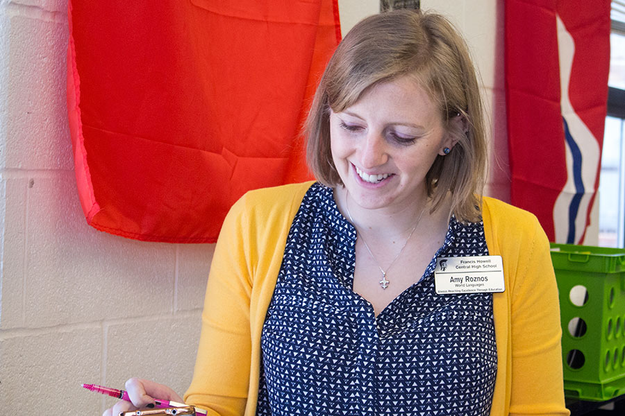 Mrs. Roznos smiles while checking a students work. She is a French teacher here. 