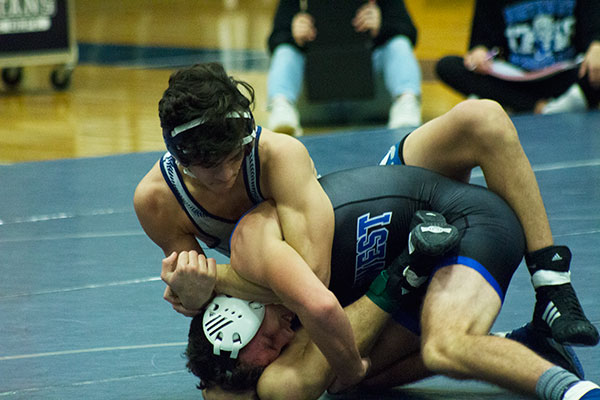 Spartan wrestler looks determined mid - match. 