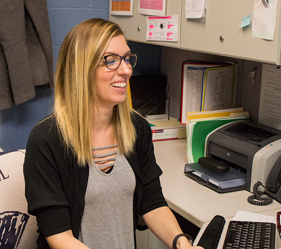 Stacey Galloway sits at her desk and explains aspects of her daily duties.