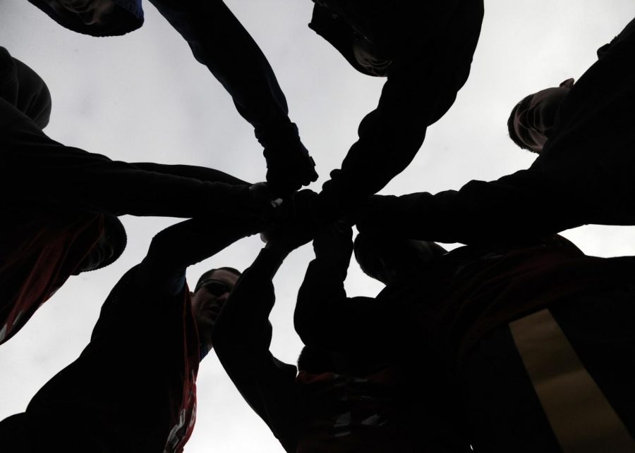 A team puts their hands in before separating for a game. Most students join an activity because they love it, and don’t expect to make friends along the way.