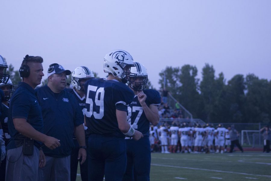 Players and coaches look on as the Spartans play their first game without Coach Todd Bizzell. The Spartans lost 43-28.