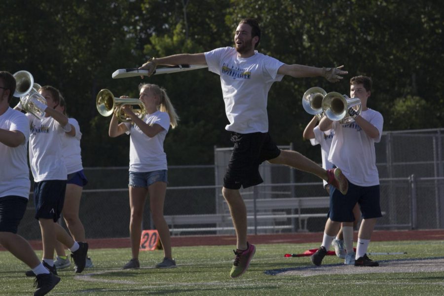 Senior Color Guard member Michael Foley leaps into their air. The routine for All in a Dayzzzzz requires a lot of flying leaps and spins from the Guard. 