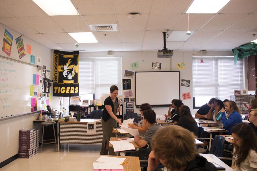 Mrs. Fetsch smiles as she passes out papers to students after accidentally allowing them to start an assignment meant for another day. Fetsch finds entertainment in every aspect of her job.