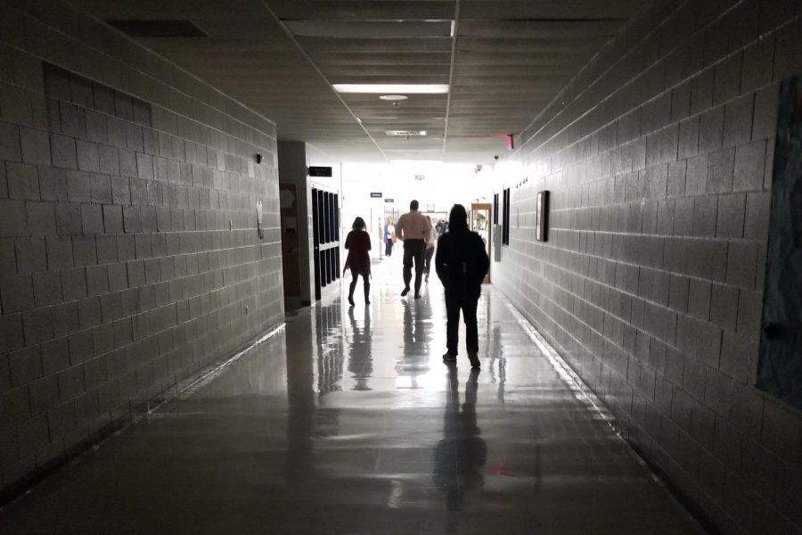 Students and staff walk towards the lit wing of the school. The power outage had only impacted the classroom side of the school, so students were guided to the gym to wait for instructions. 