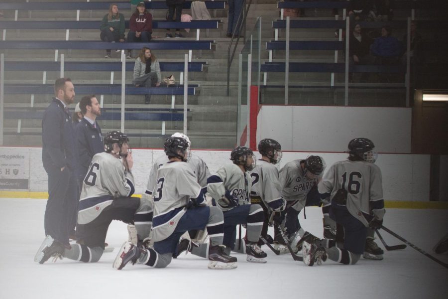 The Spartan ice hockey takes a knee as a huddled mass. The team utilizes this time to discuss the name with one another.