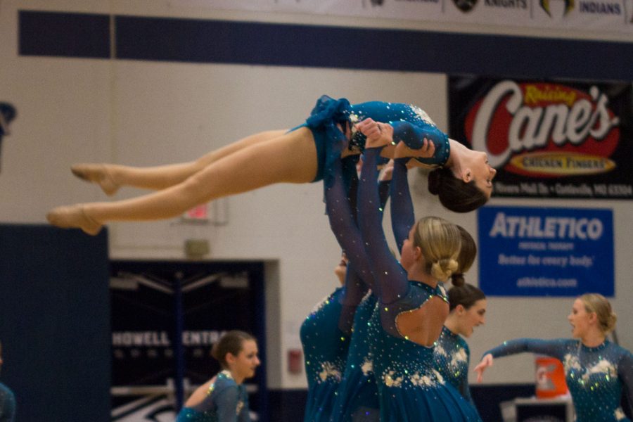 Junior Mackenzie Ryan being lifted by her teammates during their Jazz performance at the Varsity girls basketball game. 