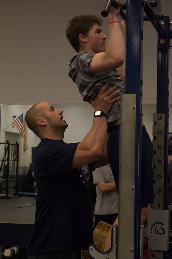 Coach Radigan assists a student with pull-ups.