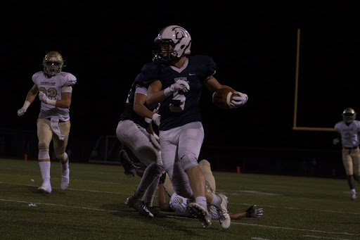 Kannon Cissell evading a defender while running along the sideline.