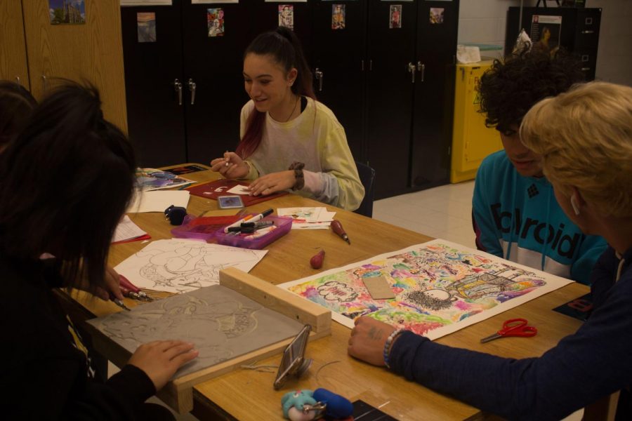 Students finish and discuss art projects. 