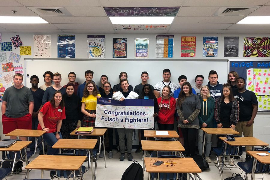 Mrs. Morrow's first hour class holds the banner they signed after winning the Penny Wars. Mrs. Fetsch will take the banner with her to the Light the Night event which also raises money for the Leukemia and Lymphoma Society each year.