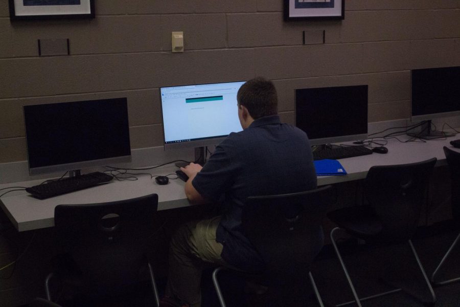 A student uses a library computer to complete an assignment. Library computers are a vital resource to students.
