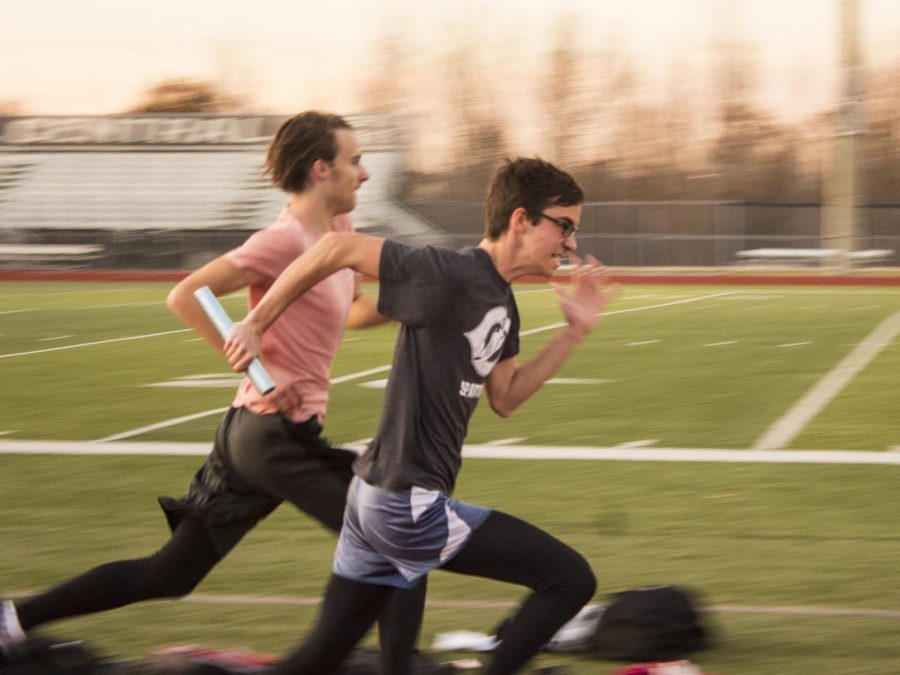 OFF-SEASON SPRINTING: Eli Allen and Reed Easterling perform handoffs with a baton. “My biggest goal is just to stay in shape and to get myself better so that during track season I can get better and better times,” Easterling said. 