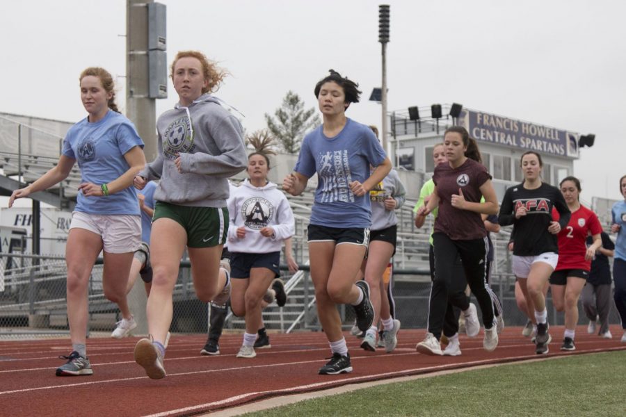 The girls soccer team runs laps around the track as part of their after school training. The team began training for the upcoming season back in November.  