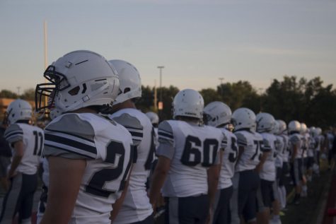 The varsity football team lines the field for the playing of the national anthem at Fort Zumwalt South, Sept. 4. With 16 players placed under mandatory quarantine, the games have been postponed until players come back Oct. 5.