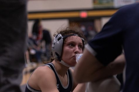 Sophomore Sophia Miller drinks water and talks to her coaches as she recovers from a fall on her head.