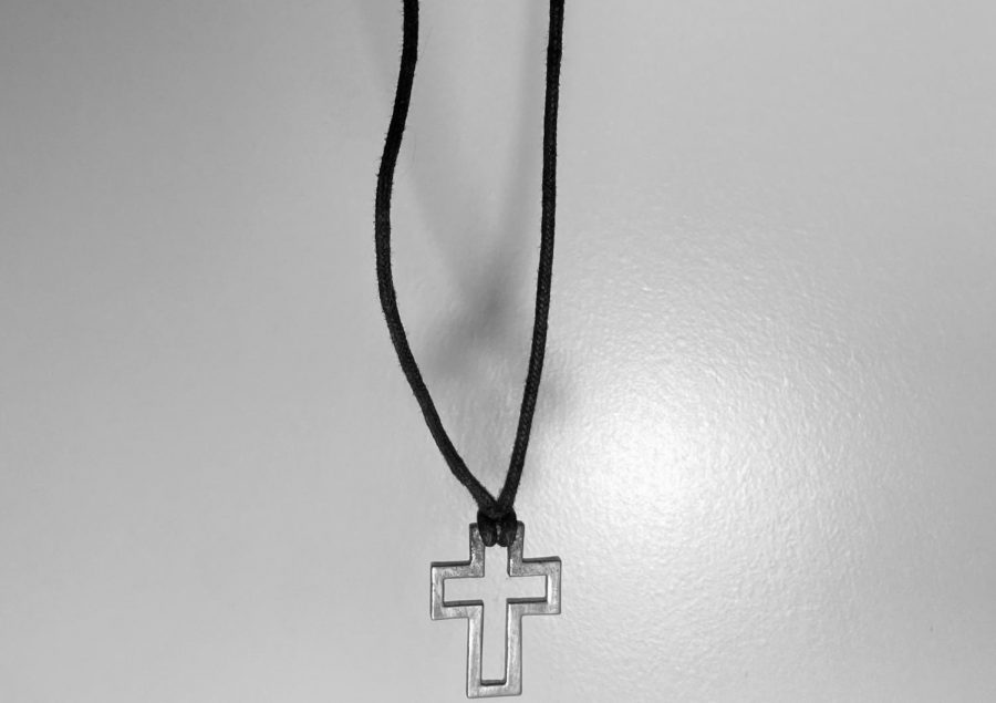 A necklace that bears the religious image of a cross is dangling, ready to drop. Letting go of something that was once so personal is very difficult no matter the circumstances; however, with religion there's a little more. The massive stigma around this act only accentuates these feelings.