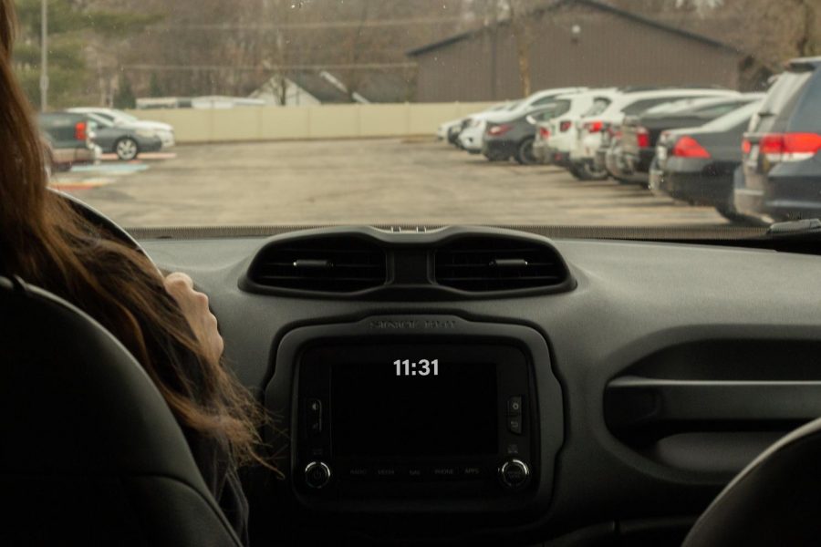 A senior student leaves school early, pulling out of the parking lot due to their shortened schedule. 