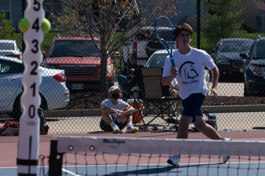 Konnor Eslinger runs across the court as the ball travels over the net towards him.