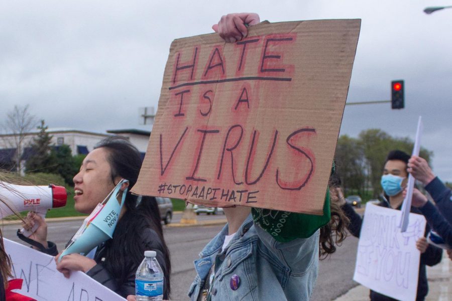 Sammi Reise holds a sign that reads Hate is a Virus.