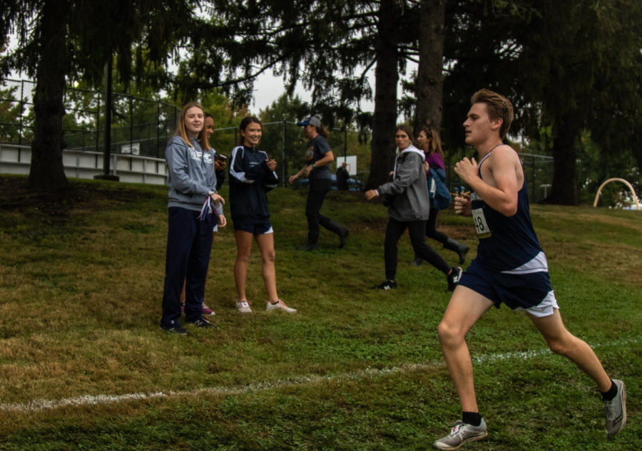 Senior Jack Schriber runs past cheering members of the JV Girls team.