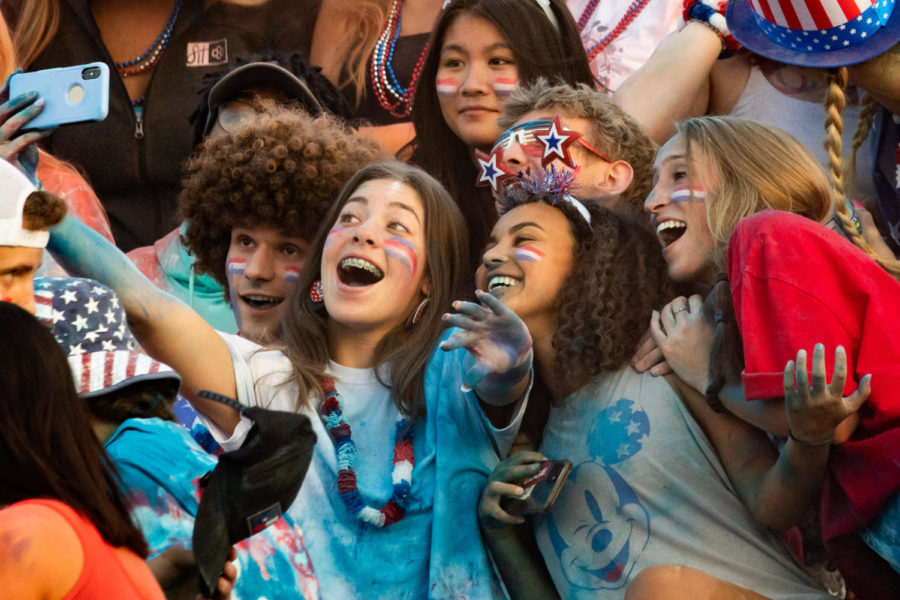  Friends gather around senior Gabi Hellman as she takes a selfie. Her and her friends are decked out in patriotic gear for the USA-themed game on Sept. 3. “I like going because we’re seniors, and we’re in the front row, so we’re kind of in control,” Hellman said. 