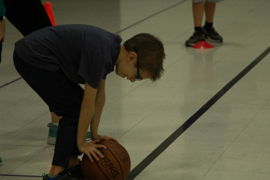 Graham leans over the ball during a relay race.