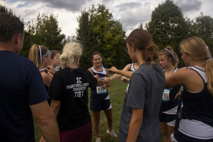 Girls varsity cross country huddles around Coach Michelle Breuer before their Warrenton meet. With the end of their season approaching, the girls for a win, little did they know that this race would allow them to go to state. 