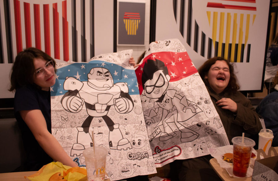 Juniors Sammi Routh and Analeisa Hollowood hold up their Teen Titans Go! posters from their happy meals.
