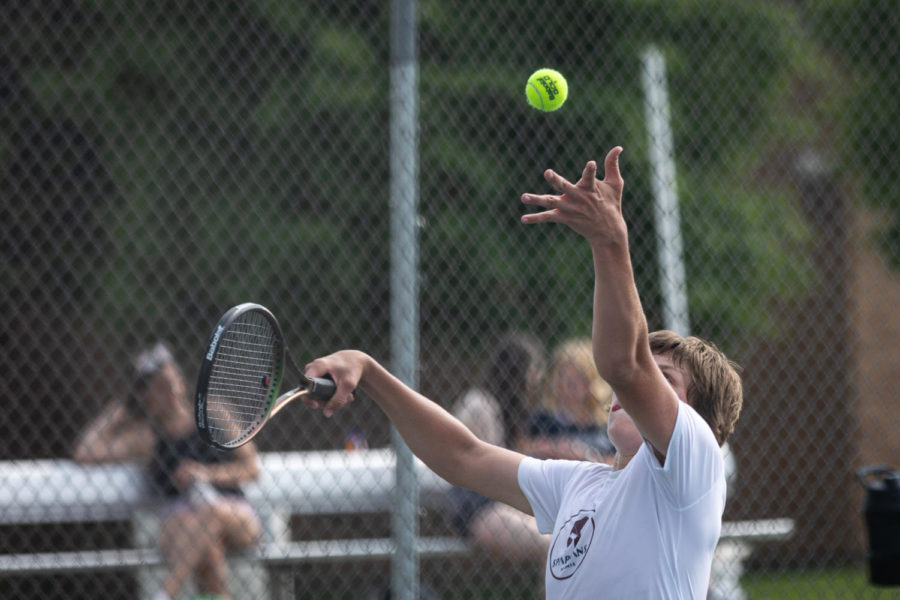 Senior Drew Black throws the ball into the air to serve it during a Varsity Districts match on May 11. This was one of the matches which helped him and his doubles partner junior Konnor Eslinger qualify for state.