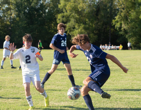 Sophomore Aiden Taylor kicks the ball away from Timberland. 