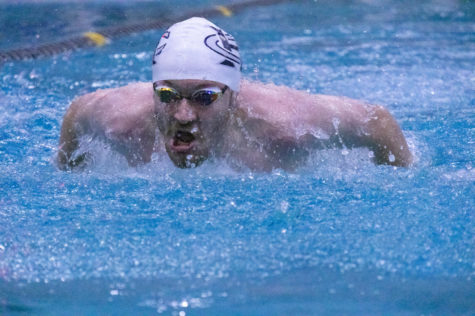 Senior Jeremiah Gabel pulls himself out of the water in the 100m butterfly event.