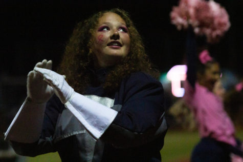  Anna Schwarm
gazes up at Mr. Griffin and Caroline to keep time while leading the band during the Pink Out game Oct 7.  In order to lead the band the majors rely on each other.