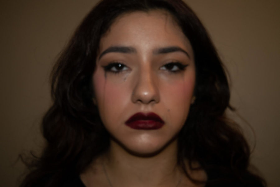 This photo portrays a young woman wearing a full face of makeup. This photo is supposed to show how women feel the need to wear makeup to cover their insecurities. 