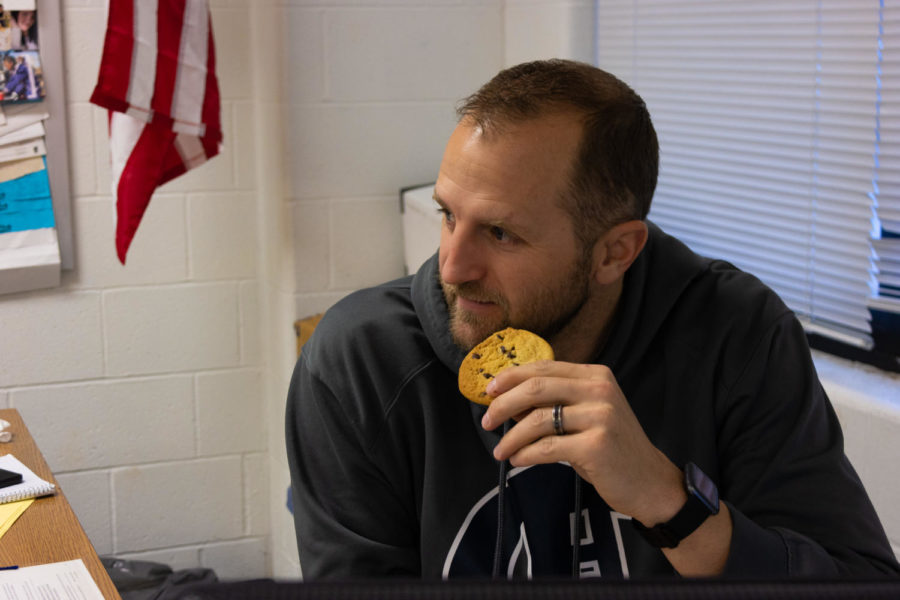 Nick Beckman talks to curious students about him posing with a chocolate chip cookie. 