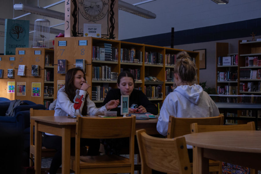A table full of students share snacks while working together.