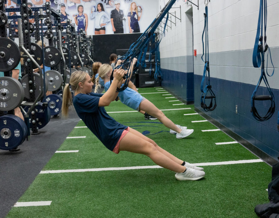 Junior Ava Lunders performs an ab workout with teammate Julia Peters. Conditioning in the pre-season helps build their stamina and endurance.