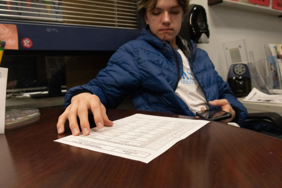 Graham Webb reviewing their new schedule sitting in the guidance office.