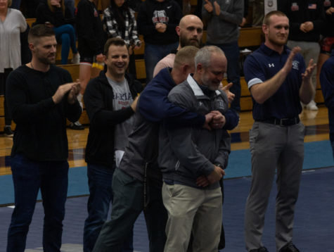 Coach Cross being celebrated by wrestling alumni. 